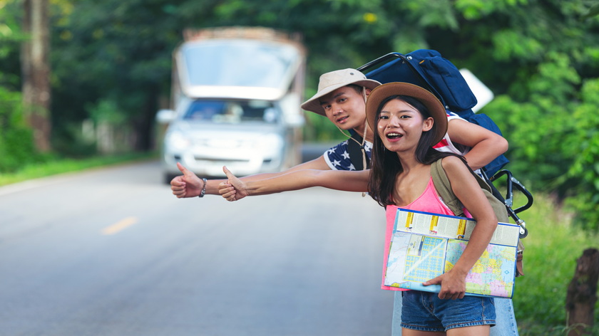 two-travellers-hitchhiking-country-side-street